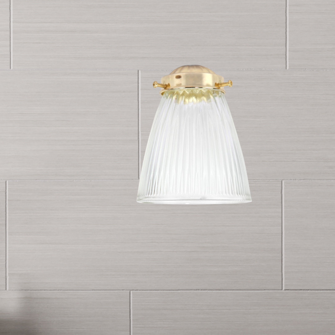 Clear ribbed replacement glass shade for Canarm light fixtures, shown with a brass-finished mounting cap against a tiled wall background.