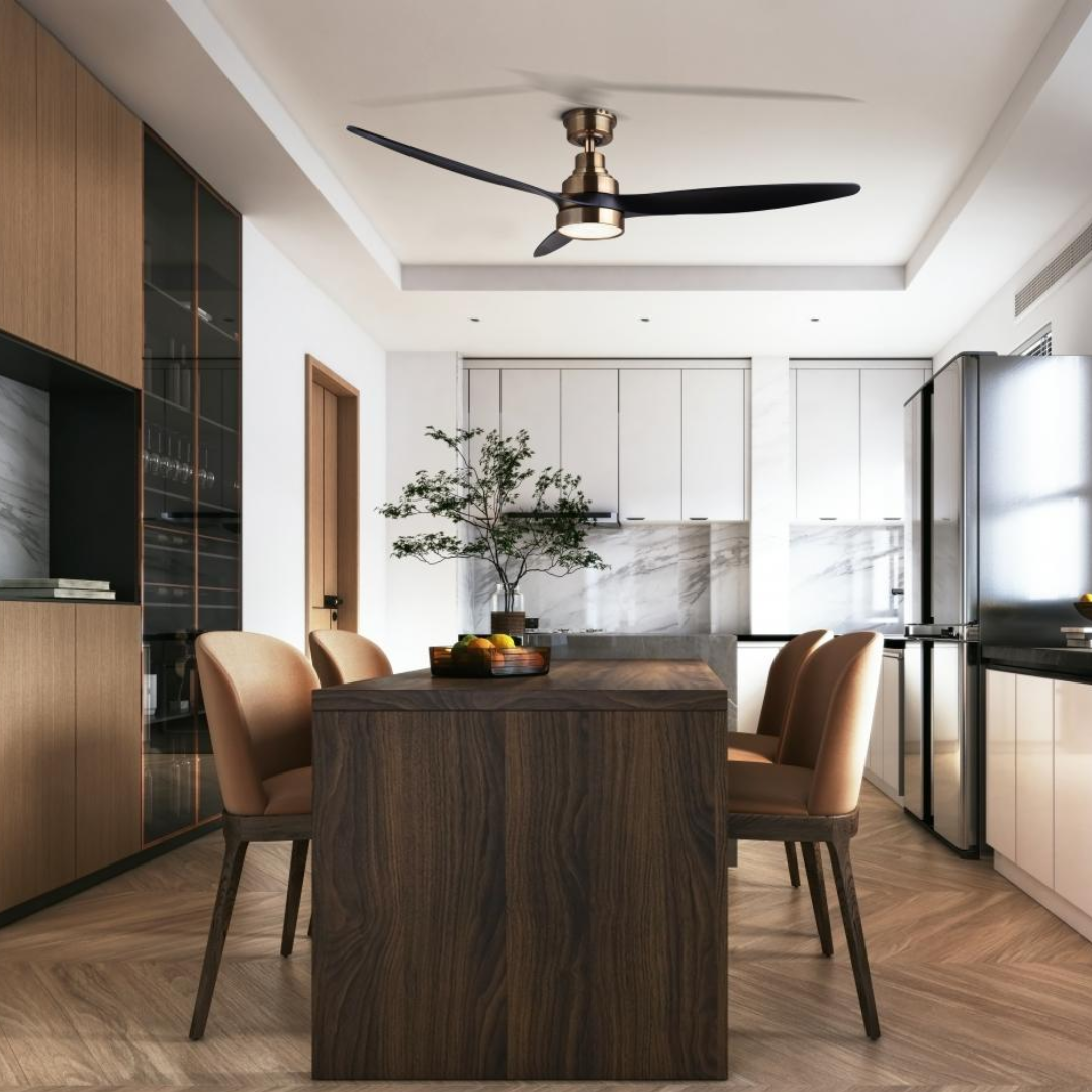 Brushed bronze ceiling fan with black blades installed in a modern kitchen and dining area featuring wood cabinetry, a dark island, and neutral-toned chairs.