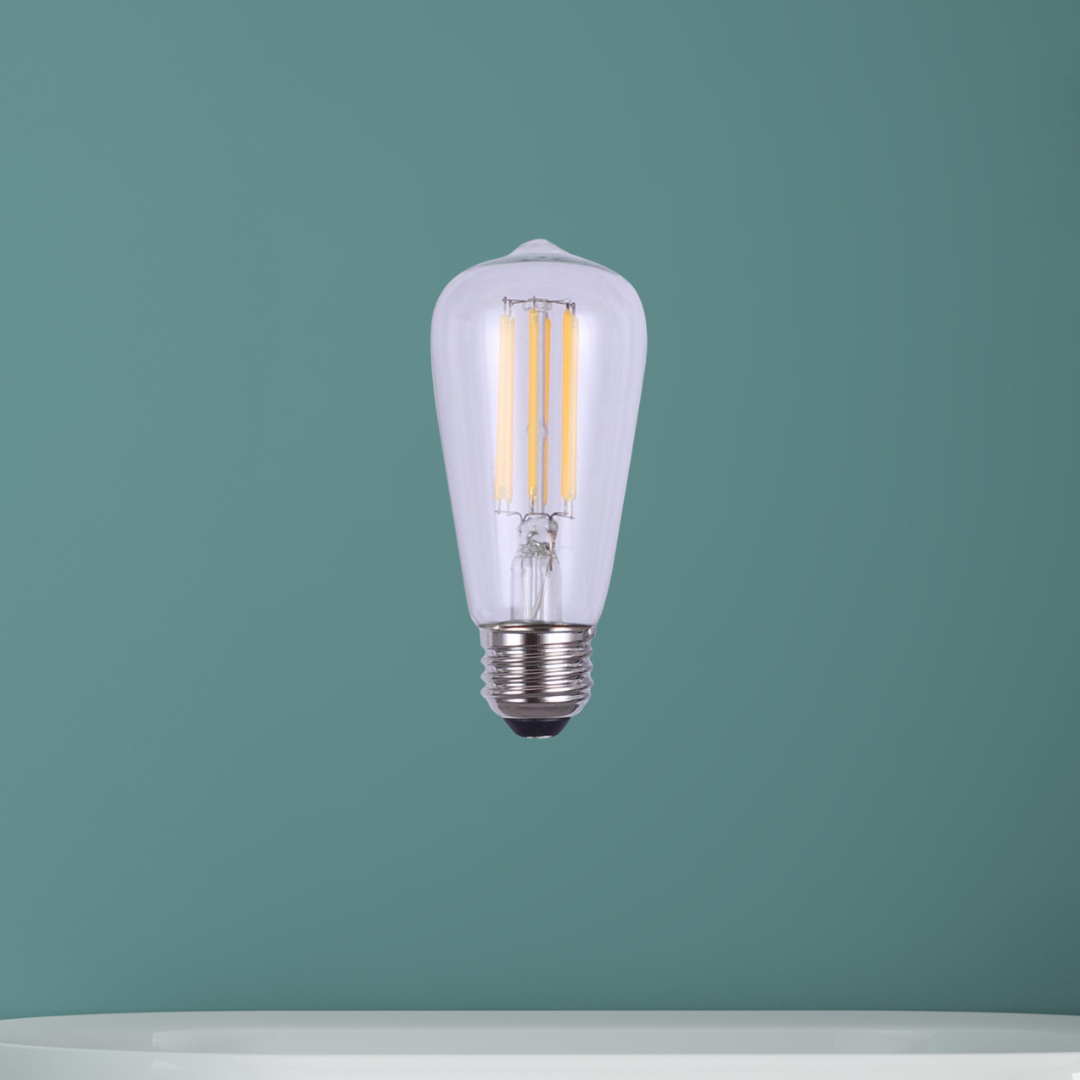 Clear LED filament light bulb with vintage-style ST shape and E26 base, displayed against a muted green background.